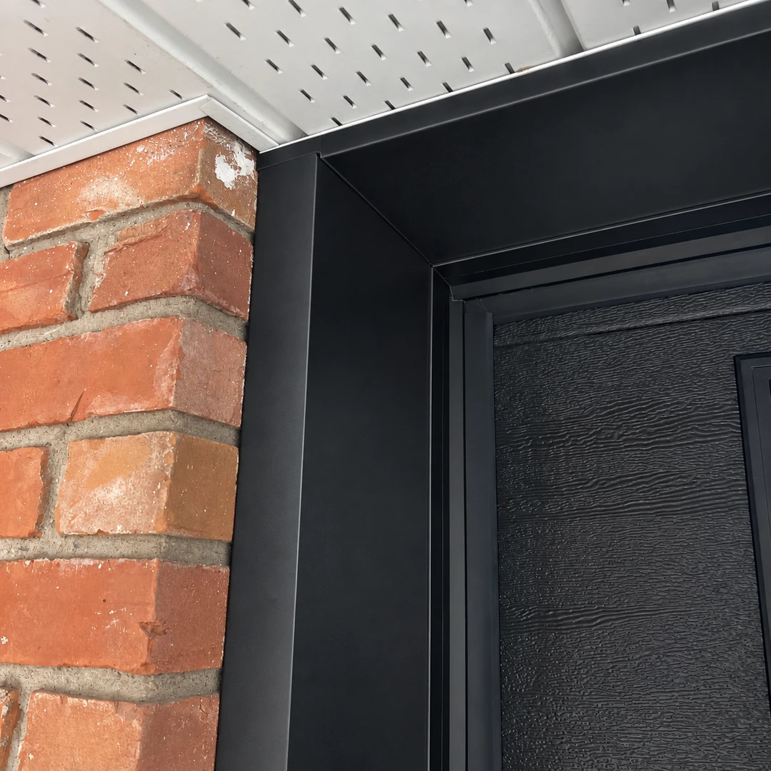 After: black trim surrounding a garage door beside brick